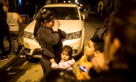 Santiago residents stand on a street outside their houses after an earthquake hit Chile’s central zone.