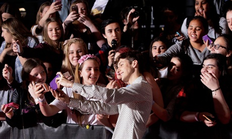 Troye Sivan takes a selfie with some fans.