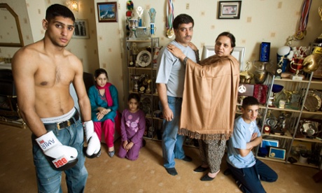Khan, aged 19, at his family home in Bolton with his parents, sisters and brother.
