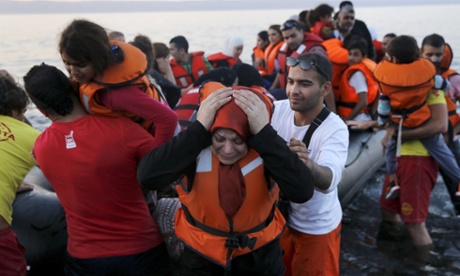 A Syrian woman reacts as she and her family jump off a overcrowded dinghy after landing safely on the Greek island of Lesbos.