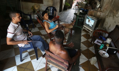 People watch on TV as the Pope arrives in Havana