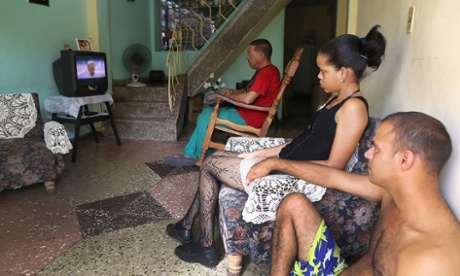 People watch on TV as the Pope arrives in Havana.