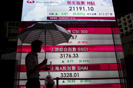 A man walks past a panel displaying figures of China stock indexes and Hang Seng Index at the financial Central district in Hong Kong, China September 2, 2015.