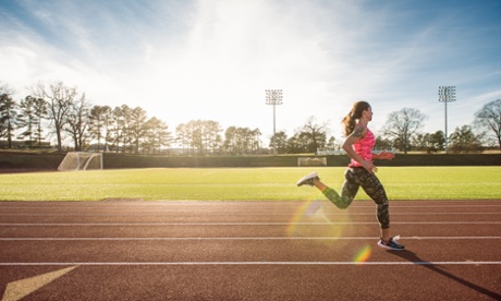 Young female athlete running on race track