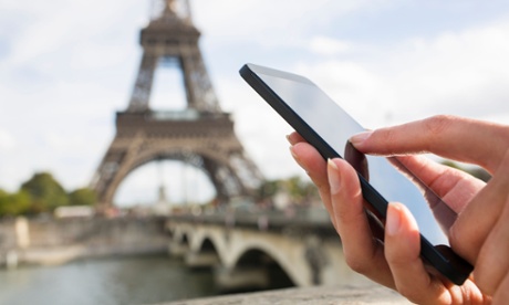 Woman using mobile phone with Eiffel Tower in background
