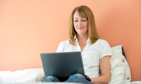 woman working on laptop in bed