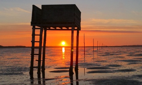 The sun rises over Pilgrims Crossing at Holy Island, Lindisfarne in Northumberland.