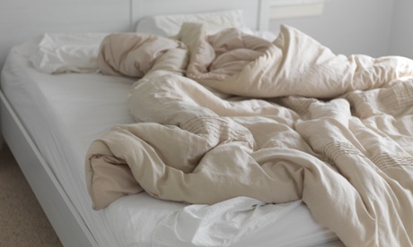 Unmade bed with ruffled blanket