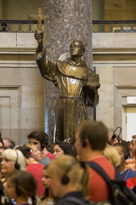 Visitors walk in front of a statue of missionary Junipero Serra in Statuary Hall, also known as the Old Hall of the House, on Capitol Hill