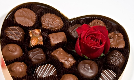 Rosebud resting on a heart-shaped box of chocolate