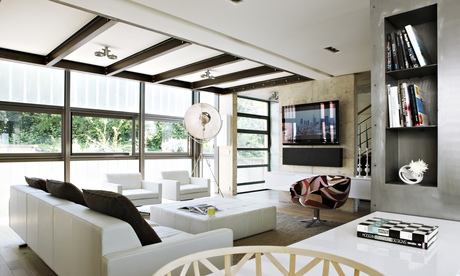 Open-plan living room with rectangular windows, leather armchairs and a swivel chair