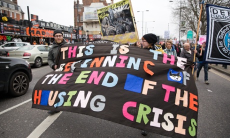 Social housing activists march with a banner stating 'This is the beginning of the end of the housing crisis'.