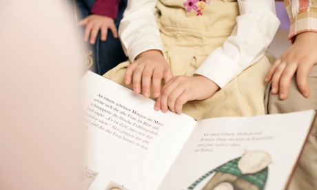 Woman reading to young children.
