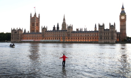Dynamo walks on water beside the Houses of Parliament.