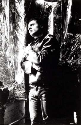 Poet and artist Gerard Malanga by a silver wall at the Factory, 1964.