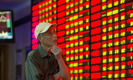 An investor observes stock market at a stock exchange hall in Nanjing, China.