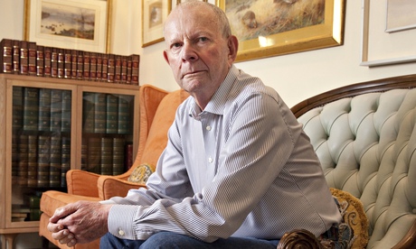 Wilbur Smith sitting on a sofa, leaning with his elbows on his legs