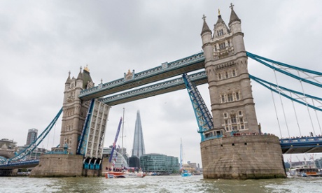 Yachts of the Clipper Round the World Yacht Race pass through an open Tower Bridge.