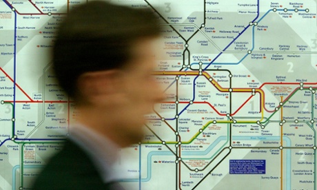 A commuter passes a map of the London Underground system at Westminster tube station.