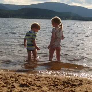 My happy children playing on the sunny shore of Loch Morlich in Aviemore