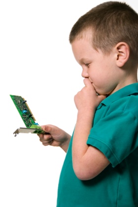 A boy looking at a computer chip