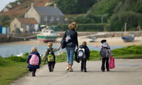 woman and four children walking to school