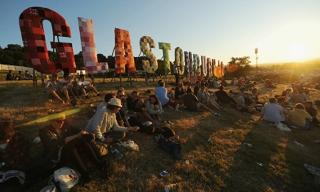 Festivalgoers in front of Glastonbury sign