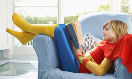 Boy reading dressed as a superhero