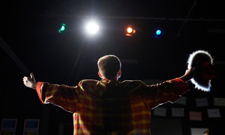 Back of child standing in front of audience during a school production.