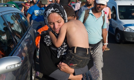 A mother and her child walk from Budapest, Hungary, towards the Austrian border.