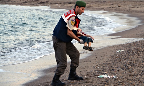 A Turkish policeman holds the body of Aylan Kurdi