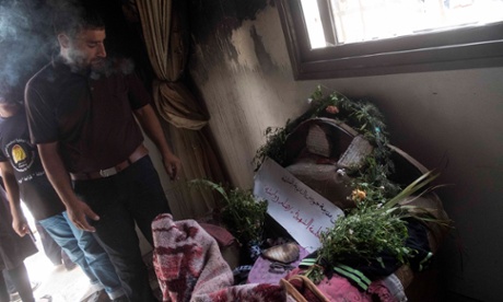 A mourner examines the crib where Reham Dawabsheh’s 18 month-old-son Ali died in the firebomb attack.
