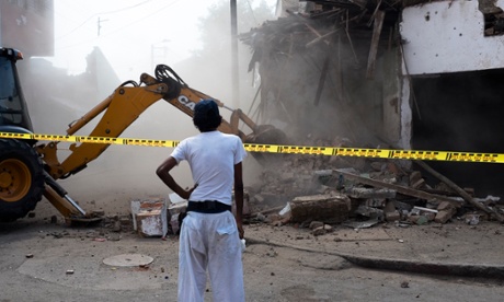 The first building in El Calvario to be demolished, watched by a woman who used to sleep there.