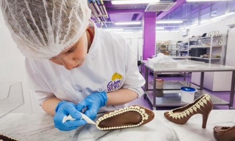 ED09EG England, Birmingham, Bournville, Cadbury World, Woman Decorating Chocolate Shoe