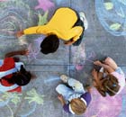 Four children drawing with chalk on pavement. Photograph: Stephen Simpson/Getty Images