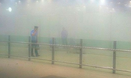Beijing airport explosion: a policeman stands amid smoke