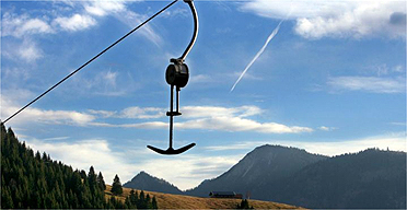 Ski lift in front of green mountains in the Alps