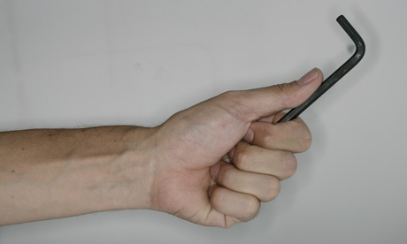 A man holds an allen key tool for DIY