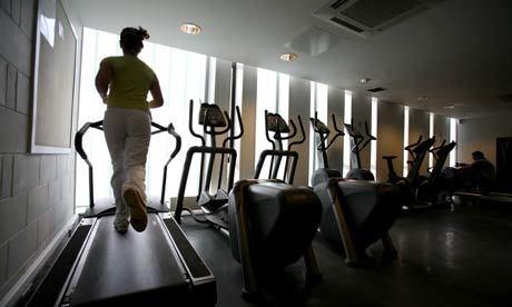 A woman exercises on a treadmill in a gym