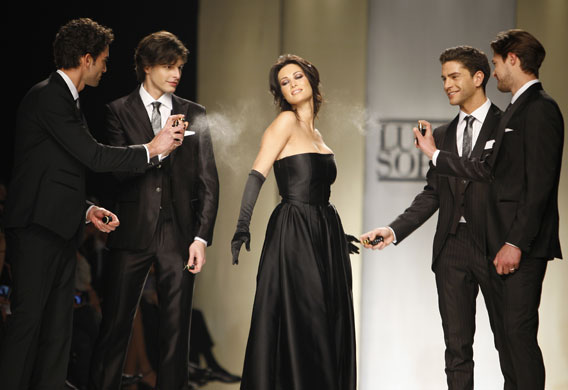 MFW: Friday: Actor Manuela Arcuri is sprayed with perfume on the Luciano Soprani catwalk