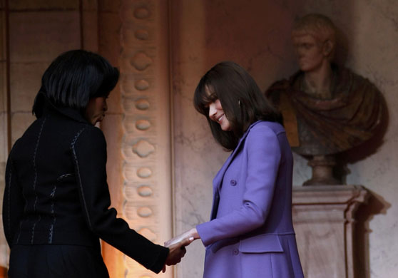Strike a pose: Carla Bruni-Sarkozy and Michelle Obama hold hands
