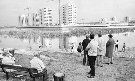 Onlookers by the lake watch the construction of Thamesmead, Greenwich, London
