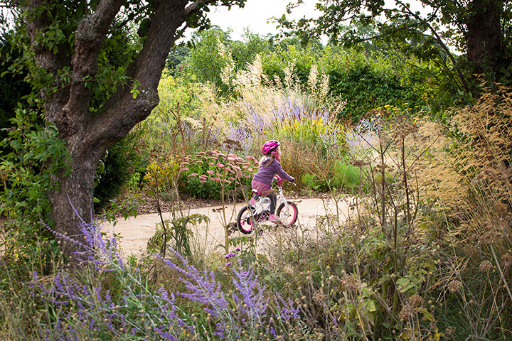 Prairie garden: Kirsty's daughter riding her bike in the garden