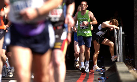 An exhausted runner pauses towards the end of the London marathon