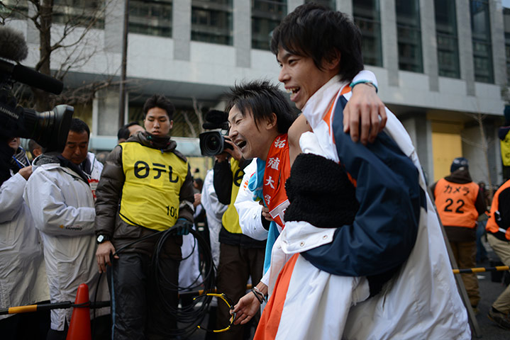 Hakone ekiden: A runner is supported by his teammate 