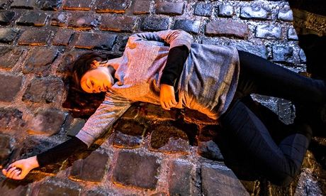 Tina lying on the cobbles in Coronation Street