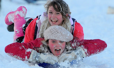 Woman and girl on plastic toboggan