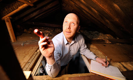 surveyor shining torch into loft