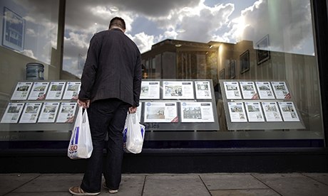 man looking in estate agent's window