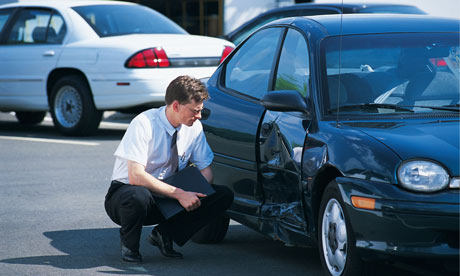motorist looking at dent in car